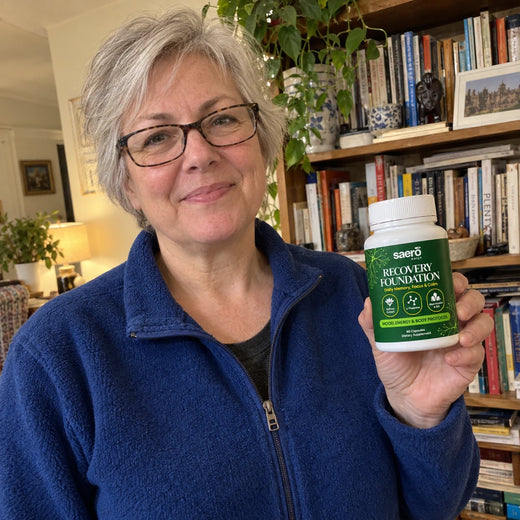 Customer by a bookshelf, holding the bottle
